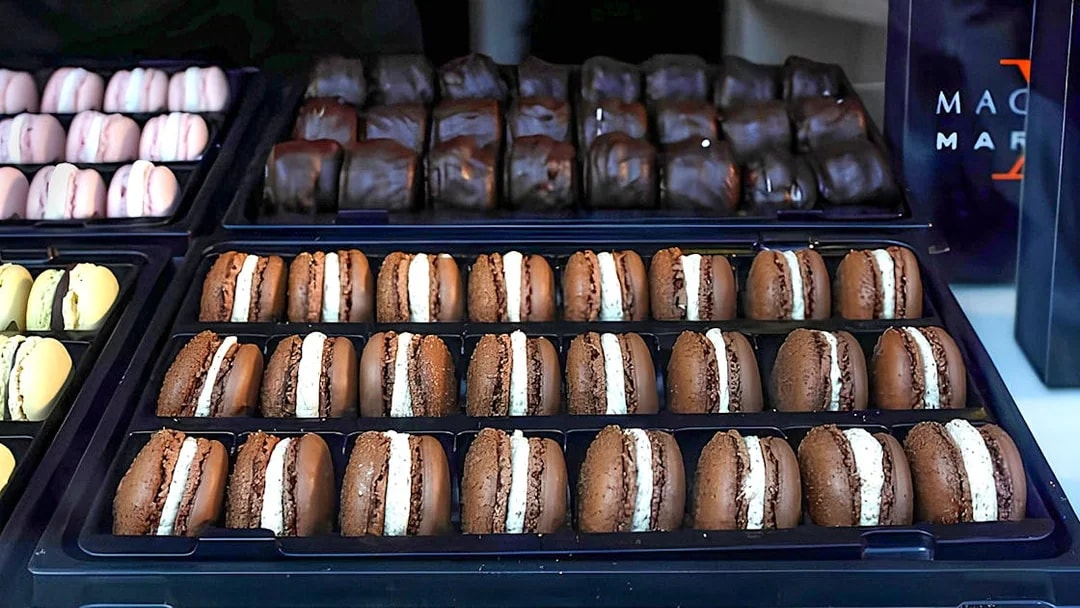 Assorted macarons displayed in trays during the Arc de Triomphe walking tour in Paris.
