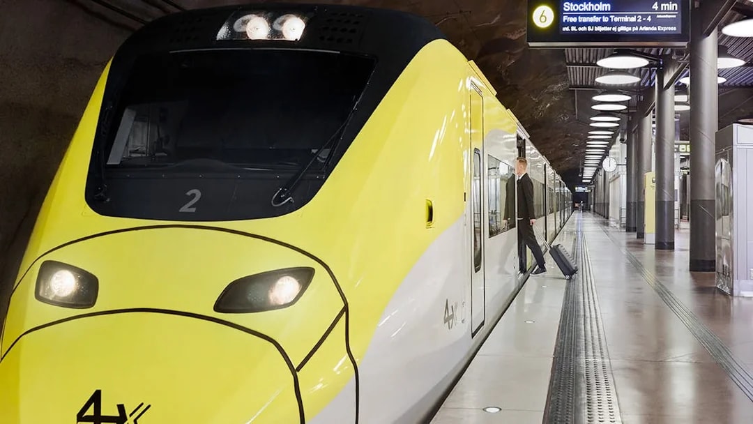 Arlanda Express train at Stockholm Arlanda Airport platform with passenger boarding.