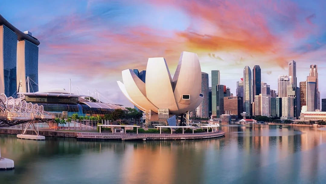 ArtScience Museum in Singapore with city skyline at sunset.