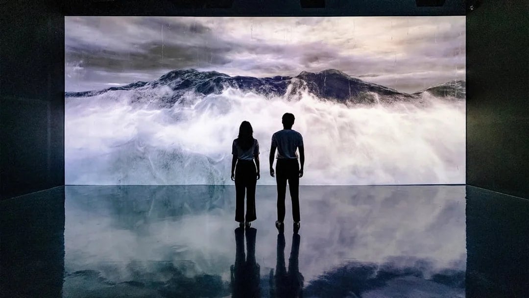 Visitors viewing ocean waves at Arte Museum Dubai's virtual experience.