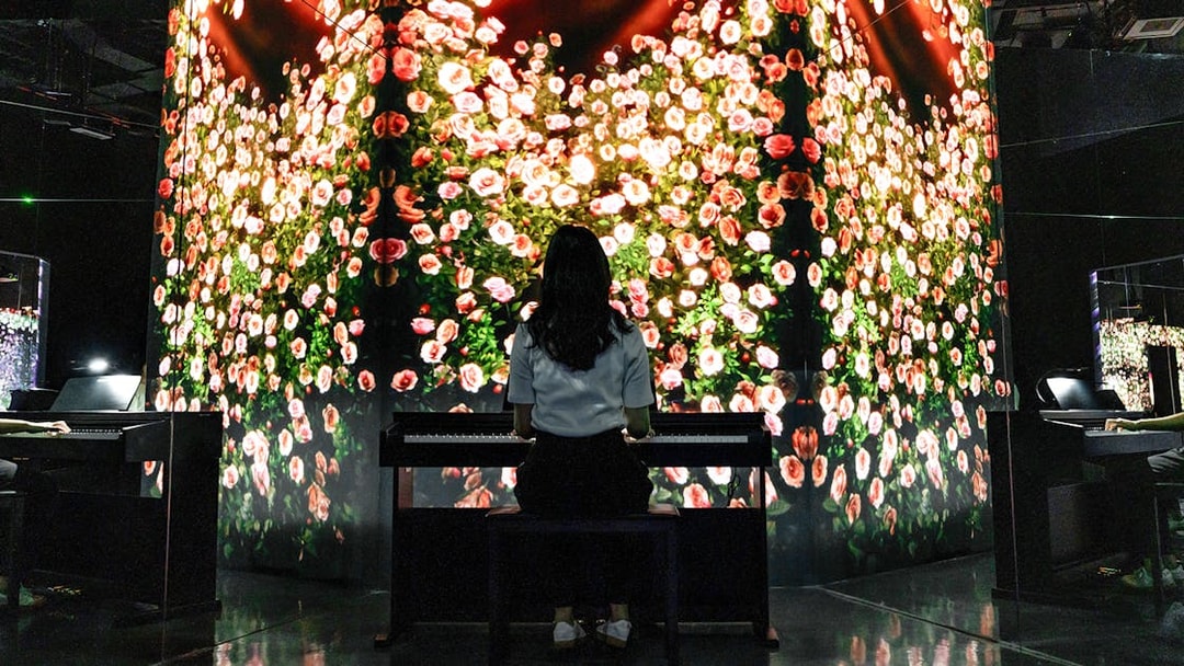 Woman at piano with rose art installation in Arte Museum Dubai.