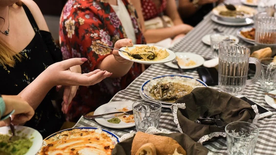 Group enjoying traditional Greek dishes at a table during Athens food tour.