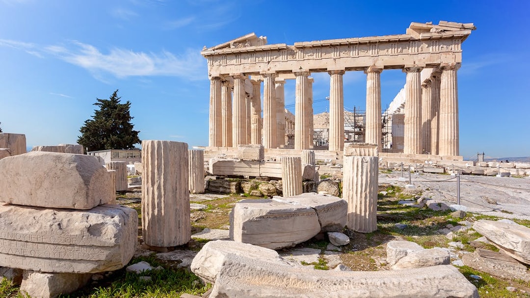 Parthenon temple ruins on the Acropolis in Athens, Greece, with scattered ancient columns.