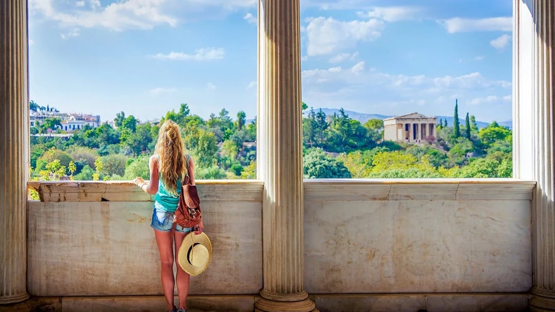 Woman viewing Ancient Agora from a marble balcony in Athens, Greece.
