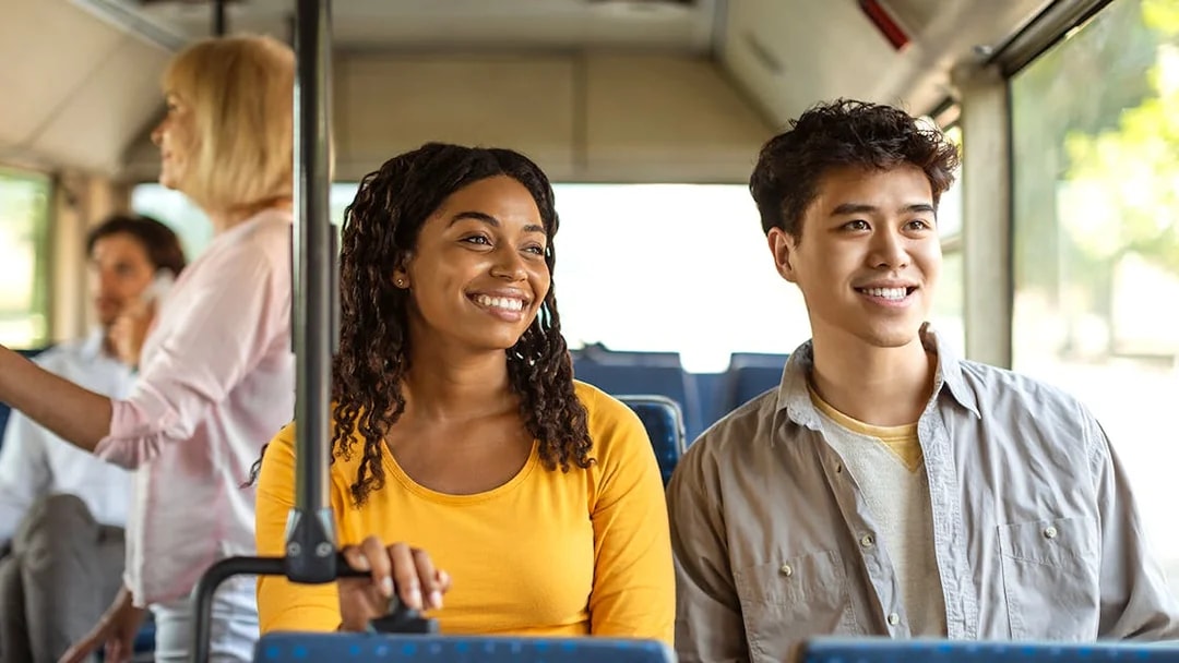 Guests smiling during a bus transfer experience.