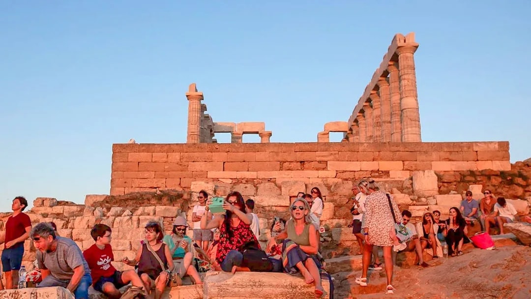 Visitors at Cape Sounion enjoying the sunset near the Temple of Poseidon.