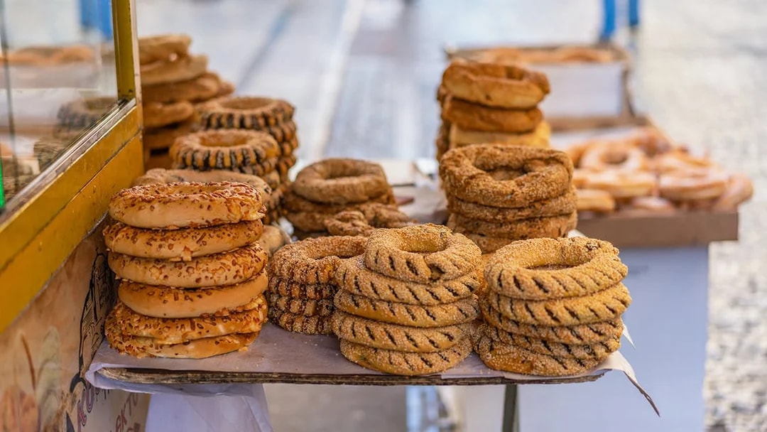 Stacks of traditional Greek sesame bread rings on a street vendor's table in Athens.