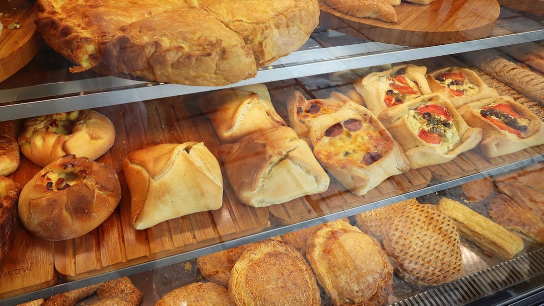 Assorted Greek pastries in a bakery display during Athens street food tour.