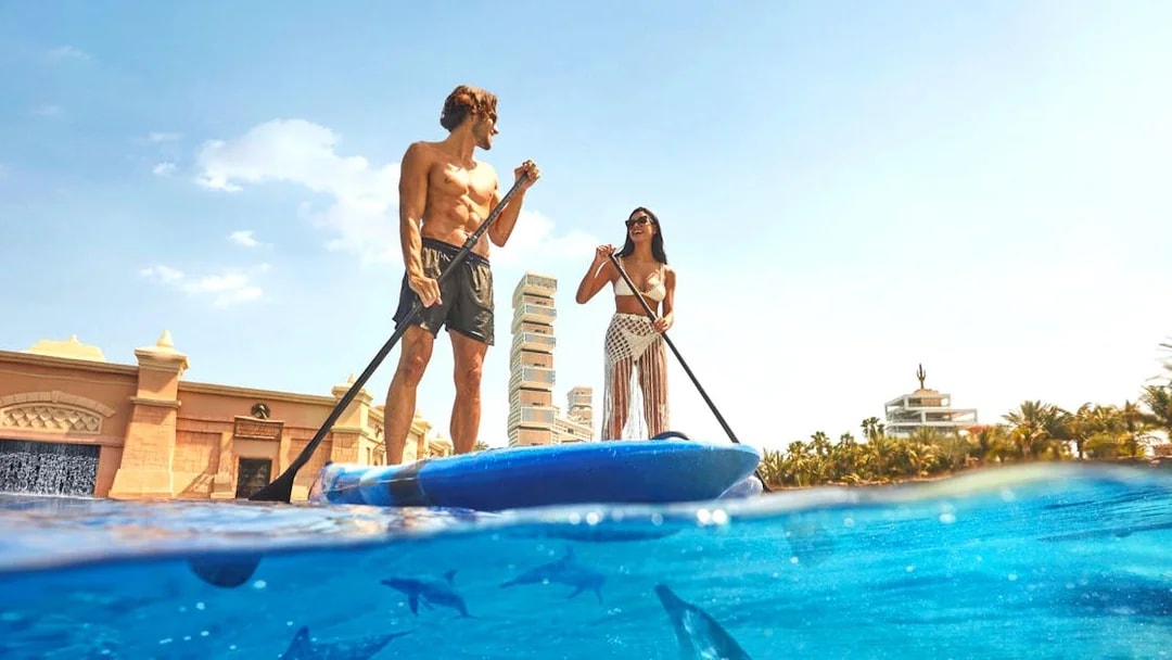 Paddleboarding at Atlantis The Palm with dolphins swimming below.