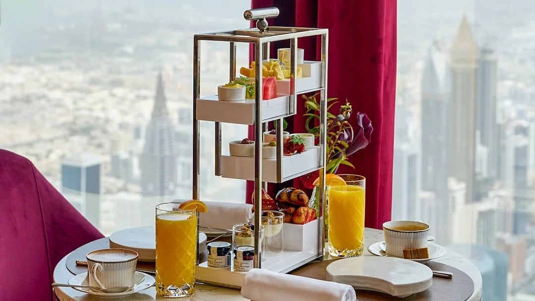 High tea setup with pastries and drinks at At.Mosphere, Burj Khalifa, overlooking Dubai.