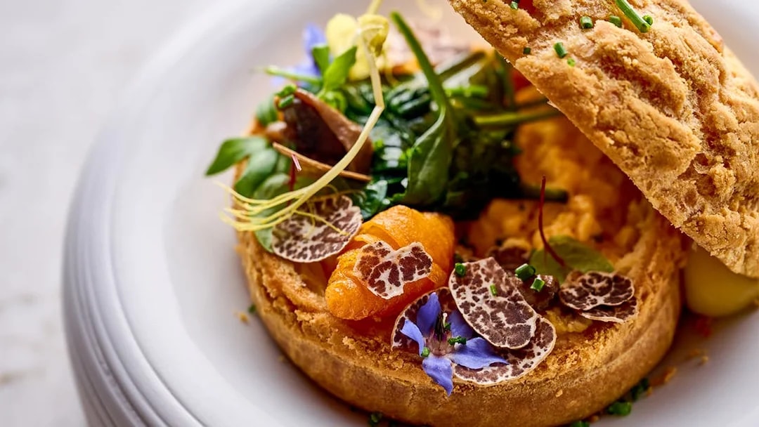 Gourmet dish with truffle slices and greens at At.Mosphere, Burj Khalifa.