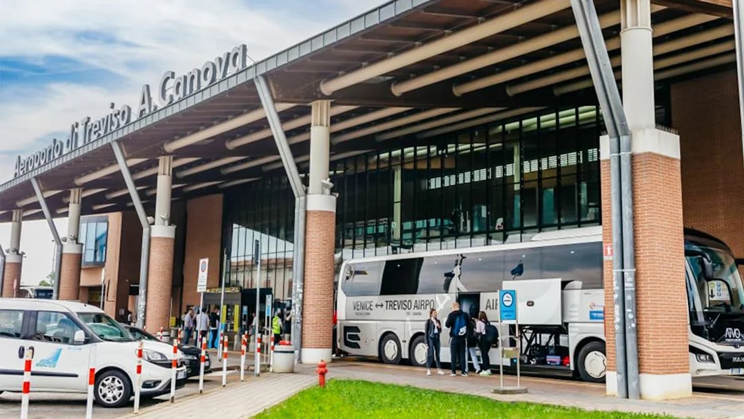 Treviso Airport bus station with passengers boarding a bus to Venice.