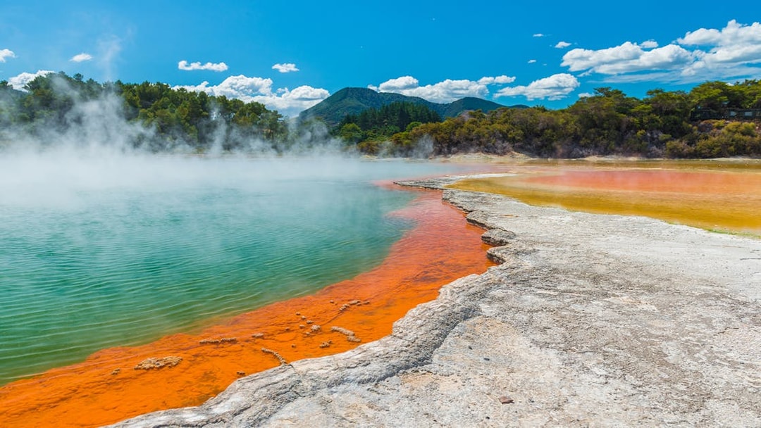 Champagne Lake's vibrant colors and geothermal steam at Rotorua Wai-O-Tapu, New Zealand.