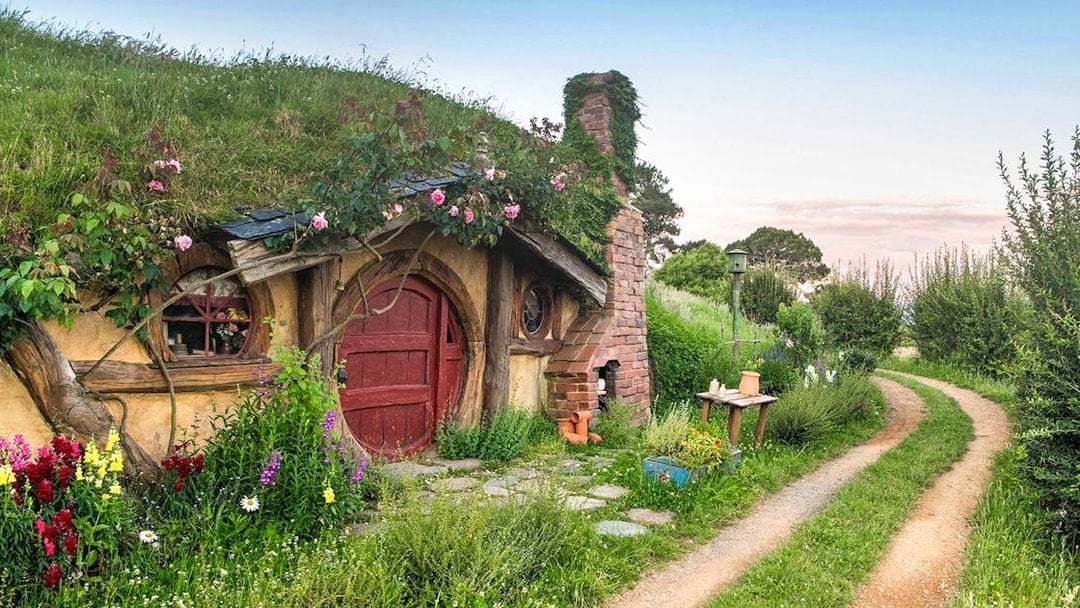 Hobbiton Movie Set house with round door and garden path in New Zealand.