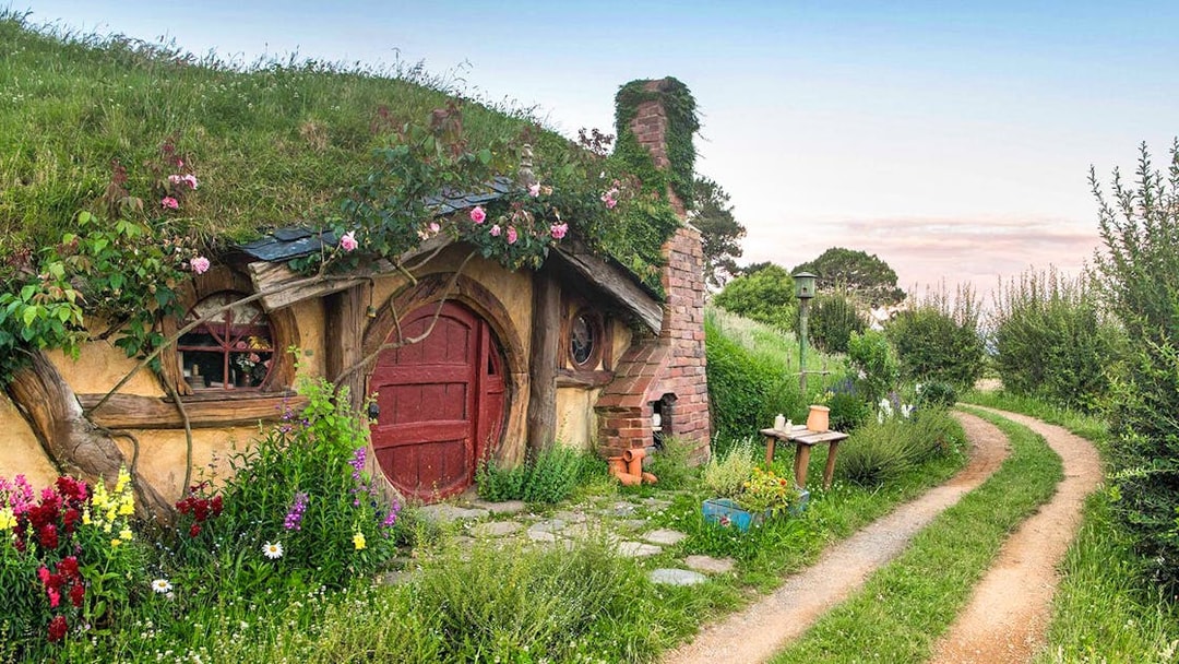 Hobbiton Movie Set house with round door and garden path in New Zealand.