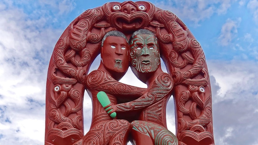 Maori carving at Te Puia, Rotorua, depicting two figures with intricate patterns.