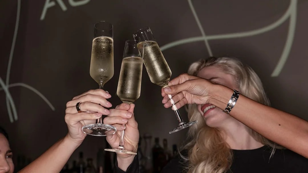Guests toasting with champagne at Aura Sky Pool.