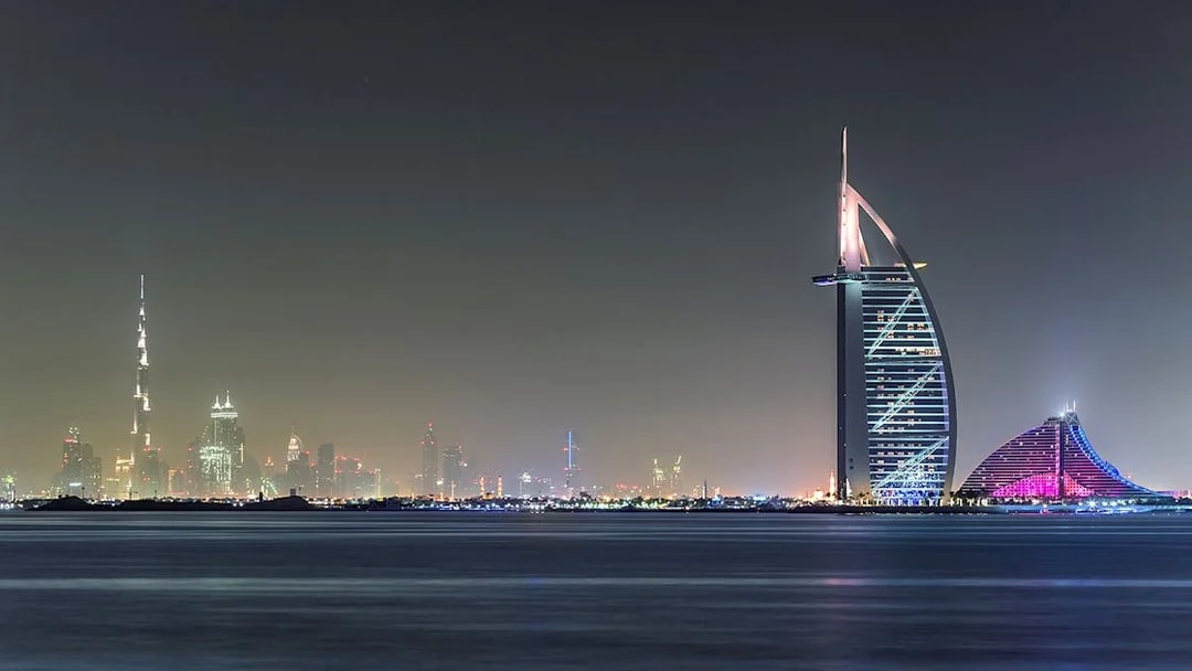 Burj Al Arab and Dubai skyline at night from Aura Skypool.