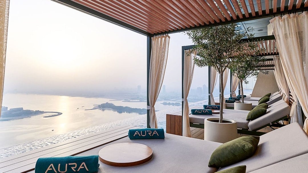 Relaxing lounge area at Rise at AURA Sky Pool with city and water views.