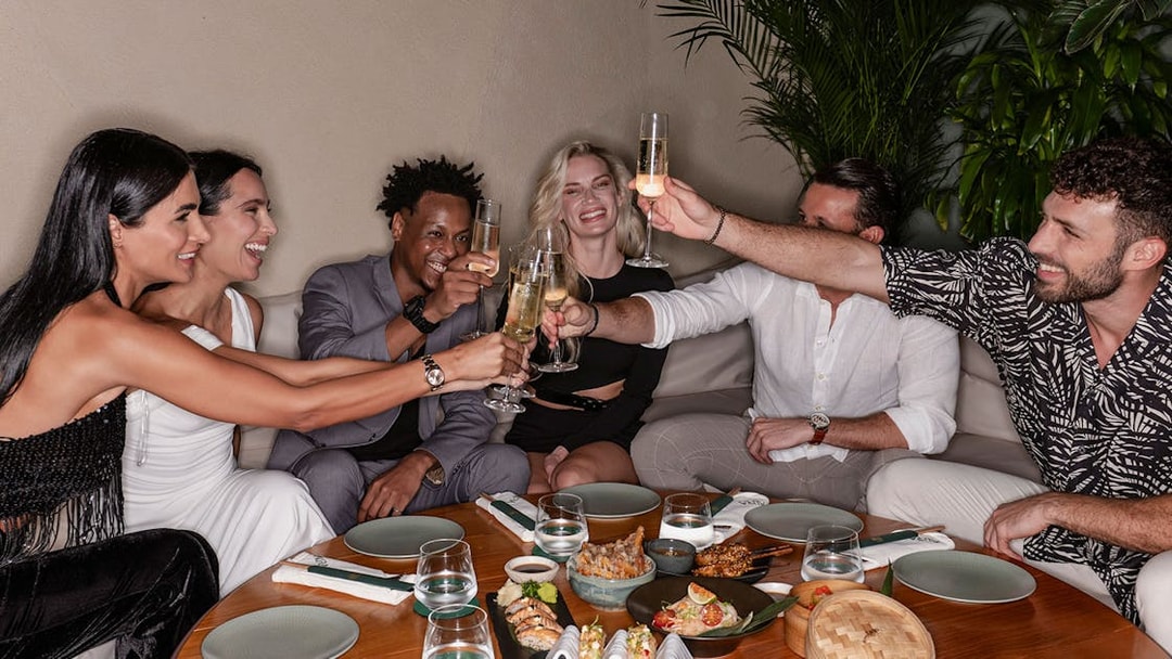 Group enjoying a meal and drinks at Aura Sky Pool.