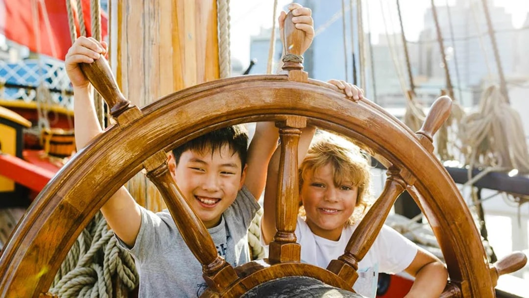 Children steering a ship's wheel at the Australian National Maritime Museum, Sydney.