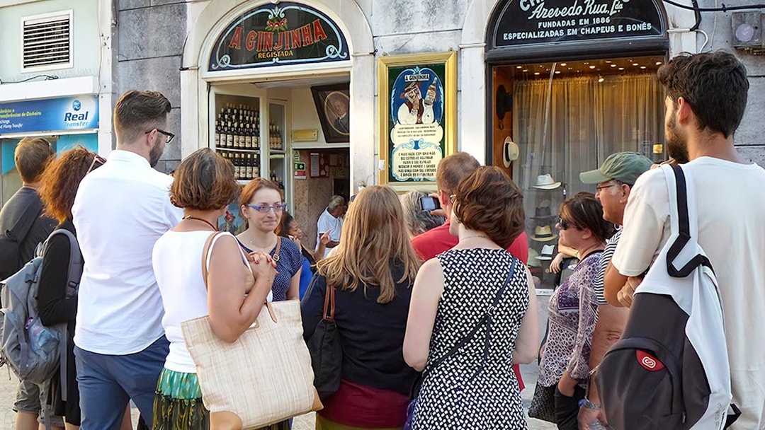 Group of tourists outside A Ginjinha bar in Lisbon during a food and wine walking tour.