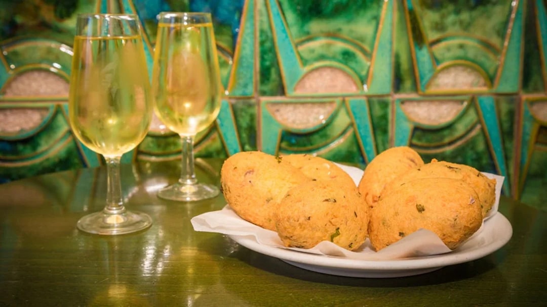 Portuguese pastries and white wine on a table in Lisbon.