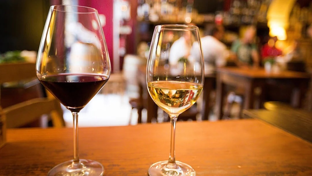 Red and white wine glasses on a table in a Lisbon restaurant.