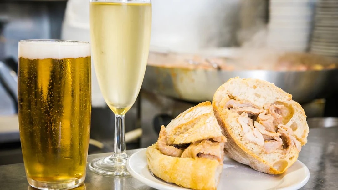 Pork sandwich with beer and wine on Lisbon food tour.