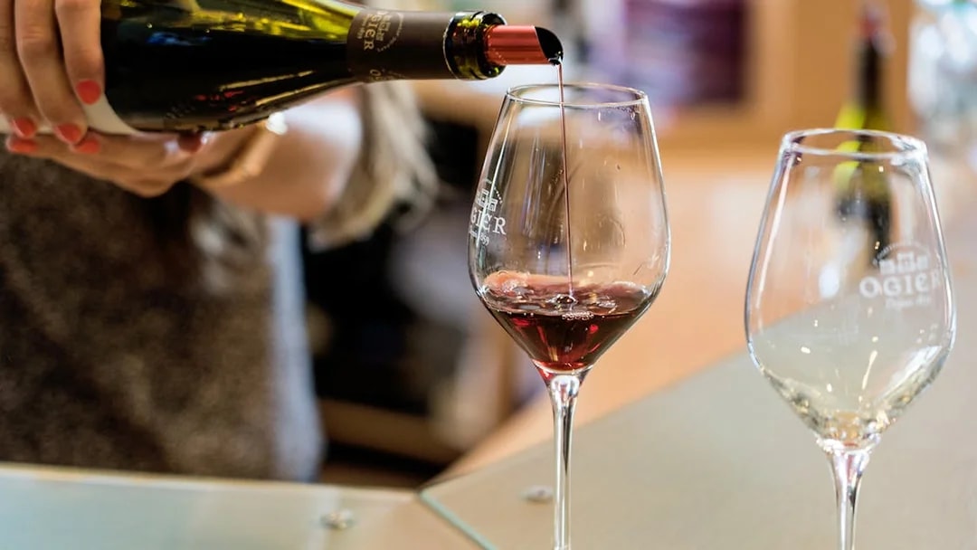 Pouring red wine into a glass at a Chateauneuf du Pape tasting in Provence.