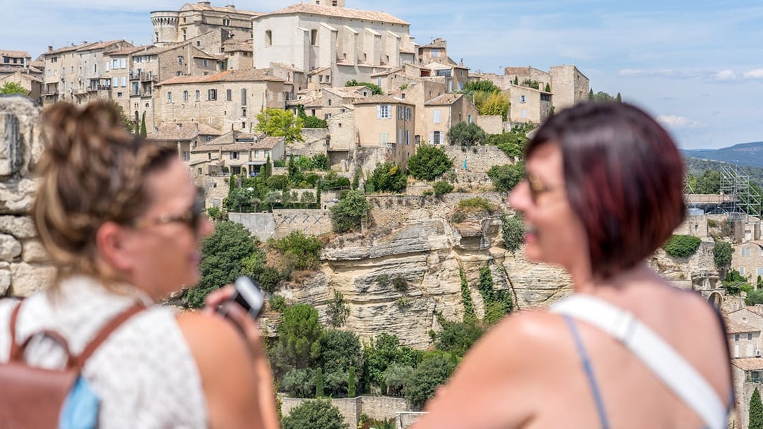 Provence village view with historic stone buildings and tourists in foreground.