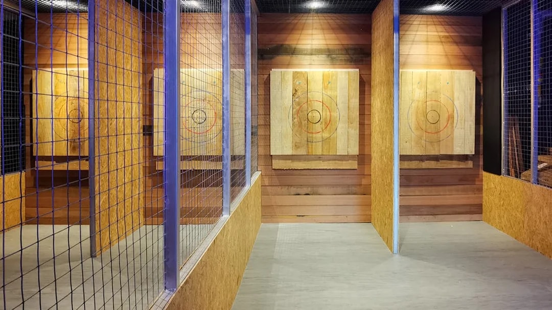 Axe throwing lanes with wooden targets at Axe Factor indoor facility.