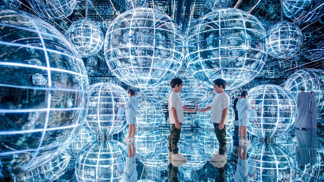 Kids interacting with glowing spheres in Luna zone, AYA universe, Dubai.