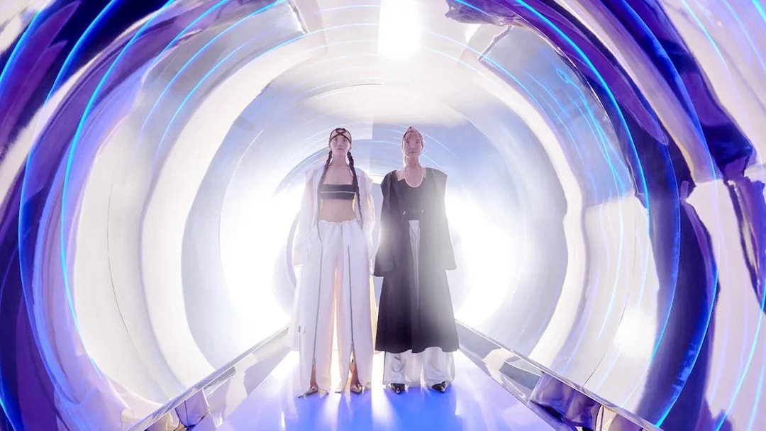 Women in high fashion at AYA Universe, Dubai, standing in a futuristic tunnel.