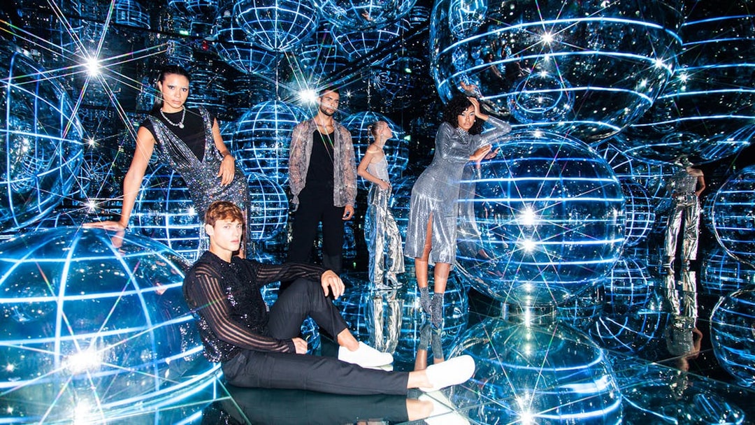 People exploring Luna installation at AYA Universe with reflective spheres and lights.