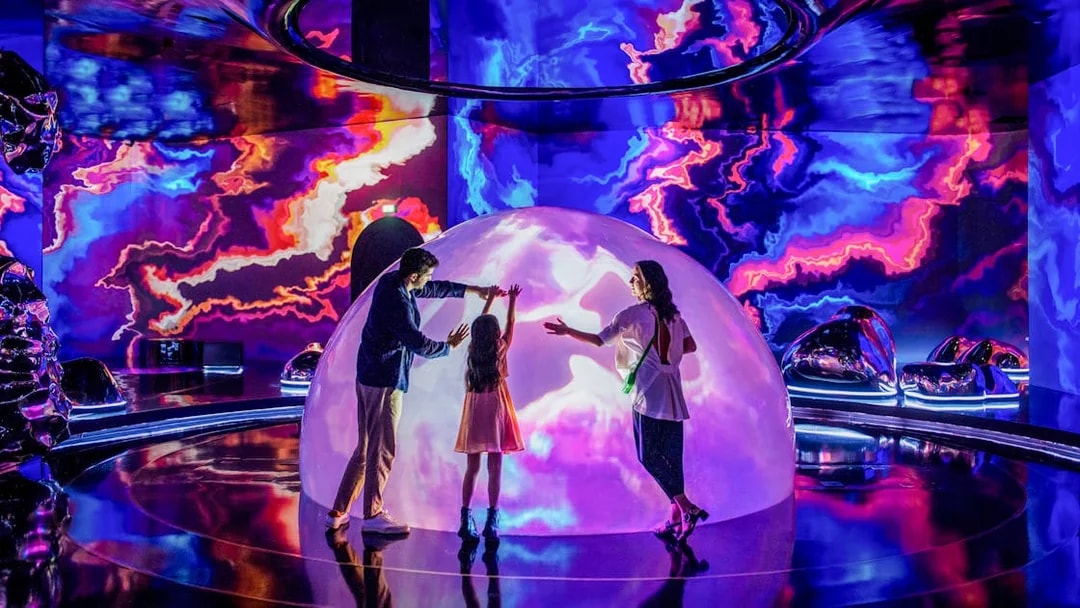 Family exploring interactive light display at The Source, AYA Universe, Dubai.