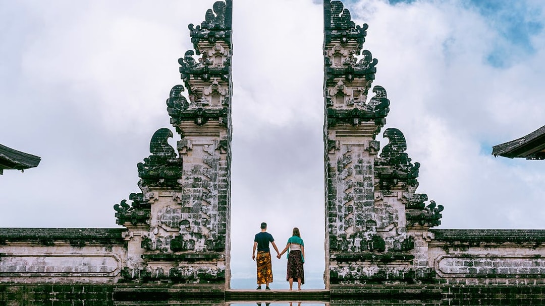 Couple holding hands at Bali's Lempuyang Temple Gates during a private tour.