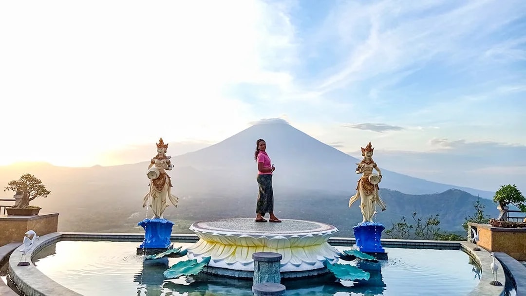 Person standing on a platform with Mount Agung in the background, Bali Fullday Private Customized Tour.