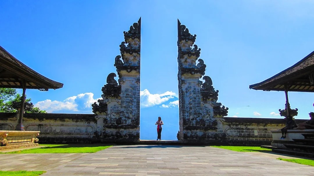 Lempuyang Temple gates with person at sunrise, Bali.