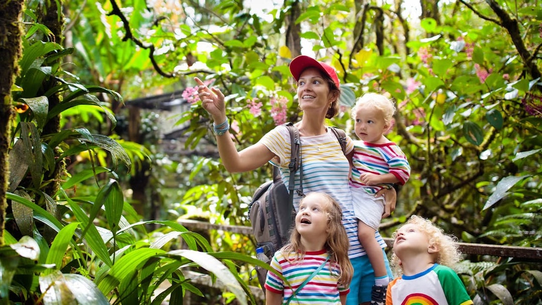 Family exploring lush greenery at Bali zoo.