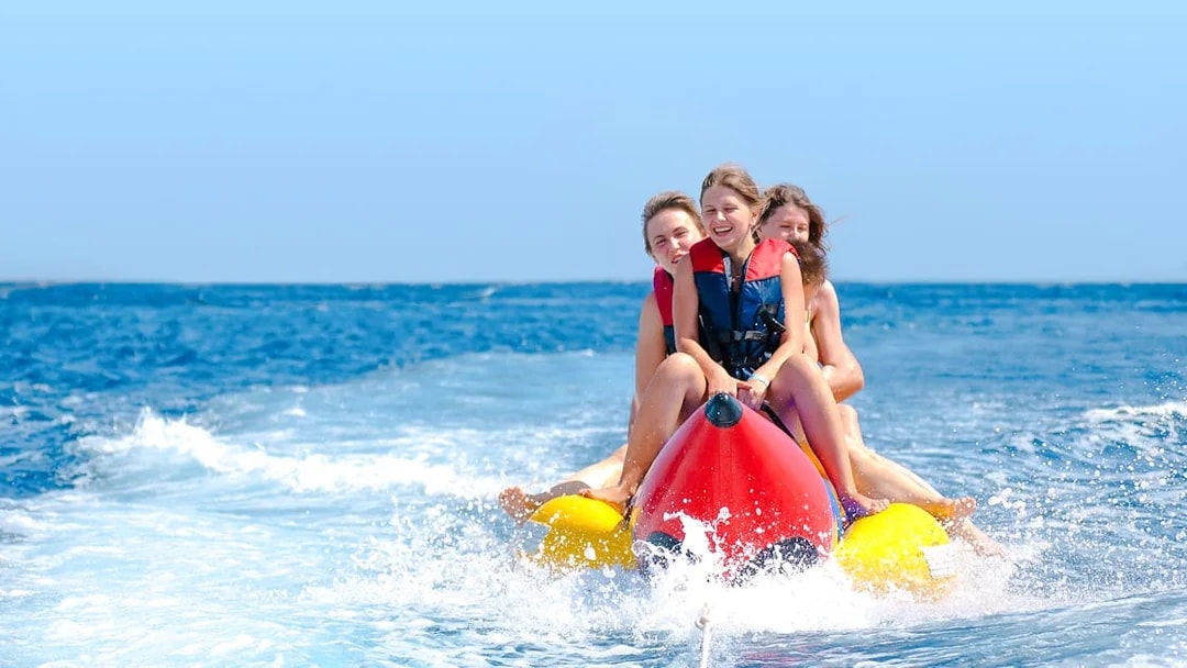 People enjoying a banana boat ride on the ocean.