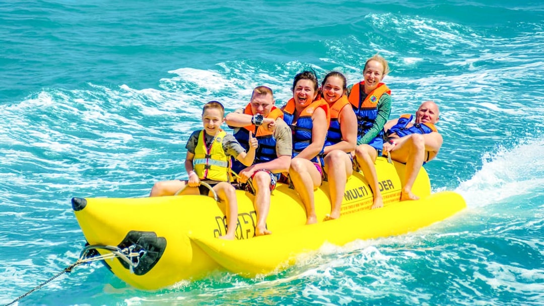Family enjoying a banana boat ride on the ocean in Dubai.