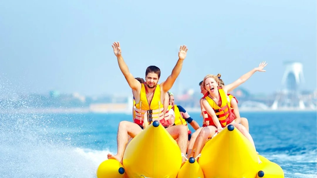 Family enjoying double banana boat ride in Dubai waters.