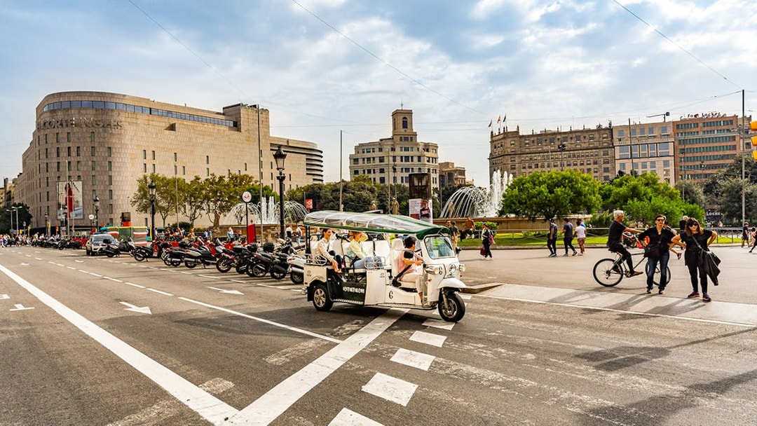 Tuk tuk driving through Plaça de Catalunya in Barcelona.