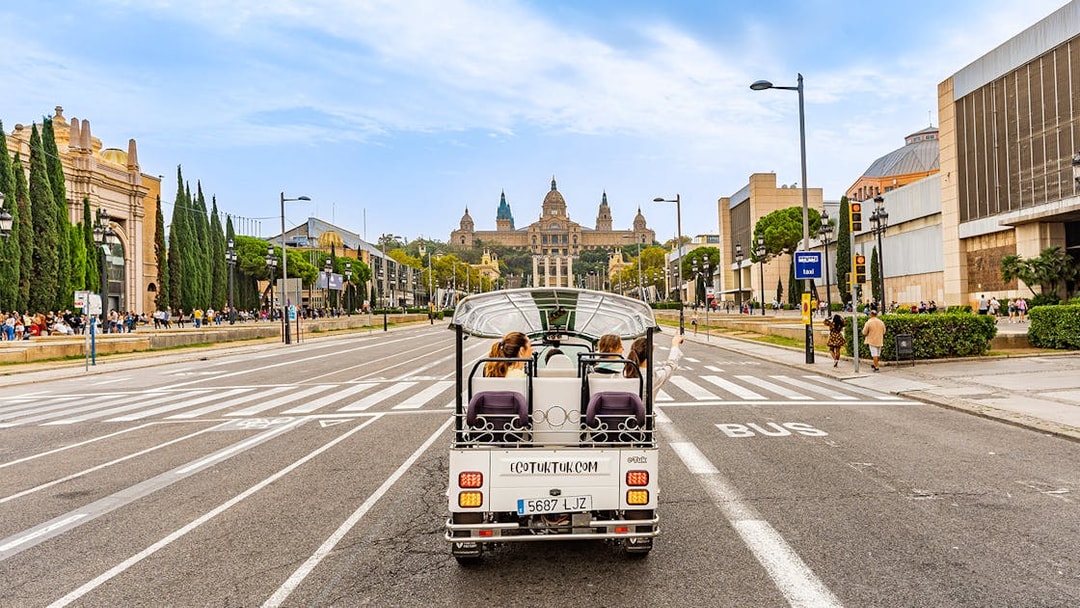 Tuk tuk driving towards the National Palace in Barcelona.