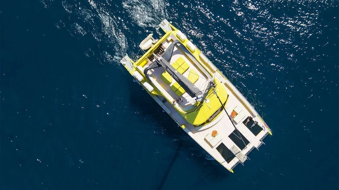 Catamaran sailing on blue waters during a Barcelona cruise.