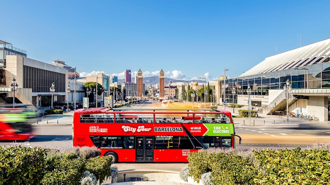 Red double-decker bus on Barcelona hop-on hop-off tour near Plaça d'Espanya.