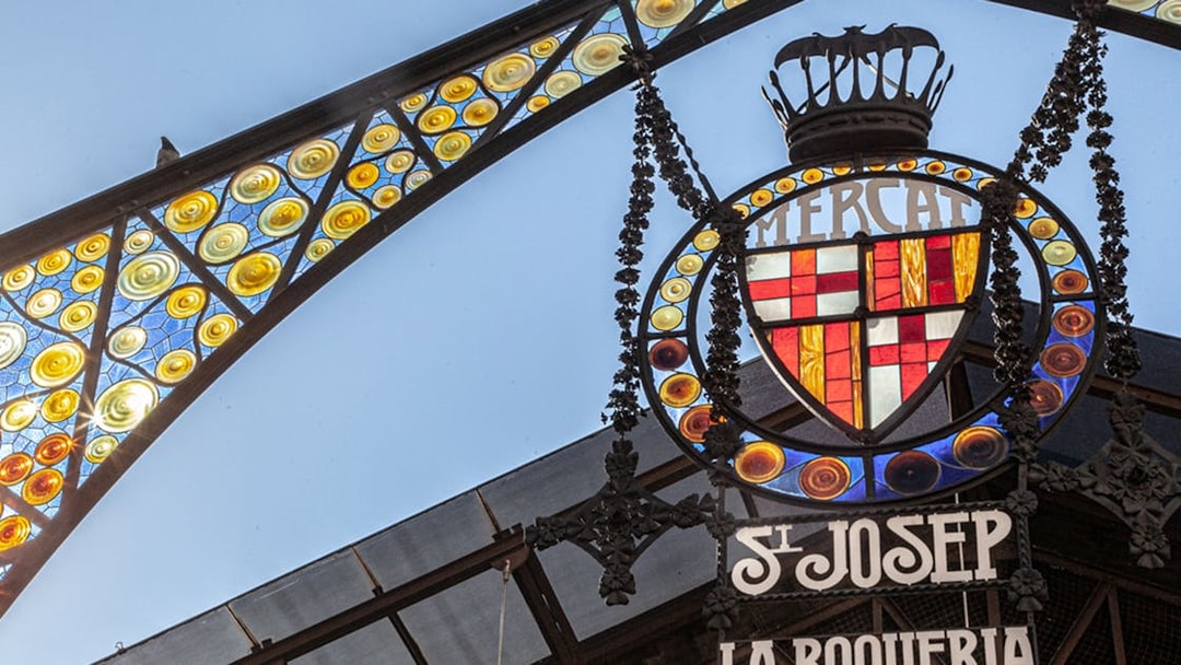 La Boquería market entrance sign with colorful stained glass in Barcelona.