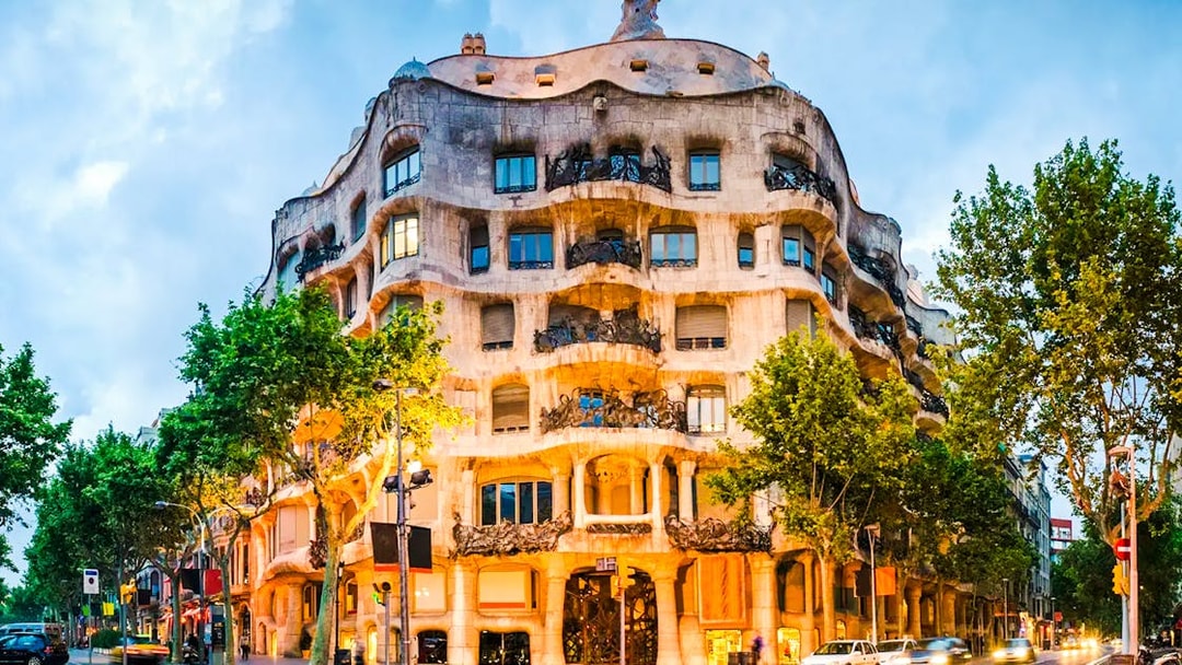 Casa Milà illuminated at dusk during Barcelona night tour.