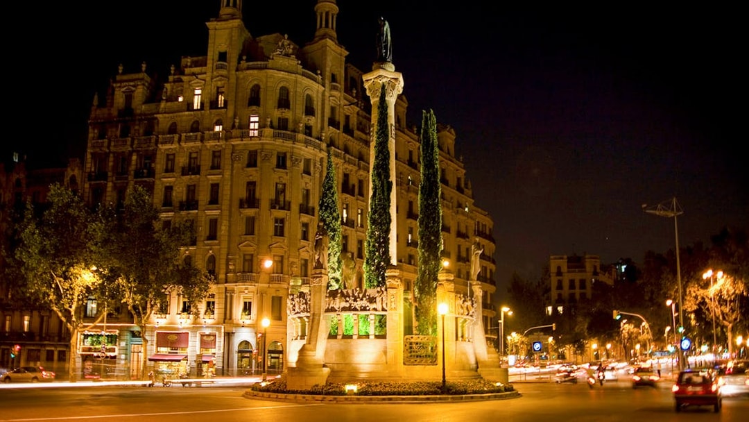 Barcelona night tour featuring illuminated historic building and monument in city square.
